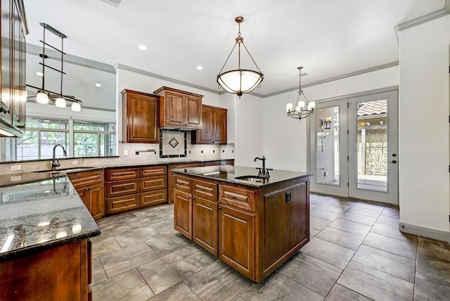 101 Blanco Ct, Horseshoe Bay, TX 78657 - kitchen featuring a sink, dark stone counters, decorative backsplash, pendant lighting, and crown molding