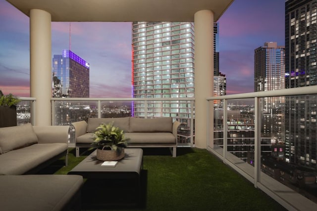 balcony at dusk featuring a city view and an outdoor hangout area