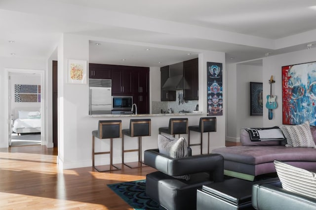 living area featuring light wood-type flooring, baseboards, and recessed lighting