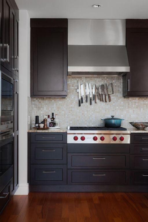 kitchen featuring wall chimney exhaust hood, stainless steel gas stovetop, tasteful backsplash, and dark wood-type flooring