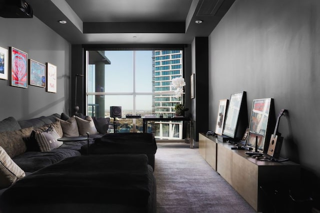 living room with carpet flooring, a raised ceiling, a wall of windows, and recessed lighting