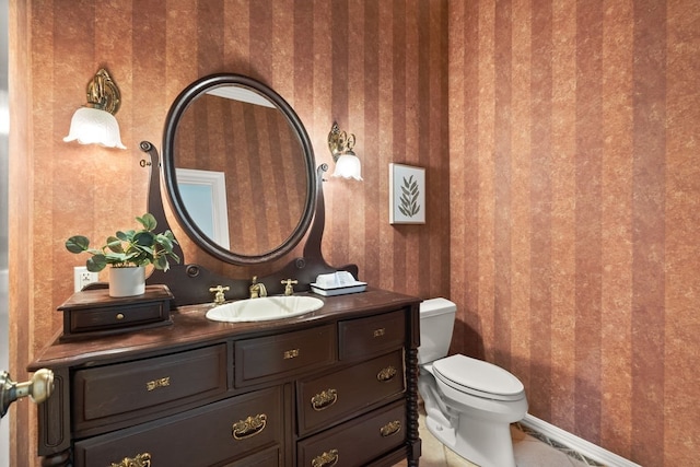 112 Oak Ct, Bastrop, TX 78602 - half bath featuring wallpapered walls, toilet, vanity, and baseboards