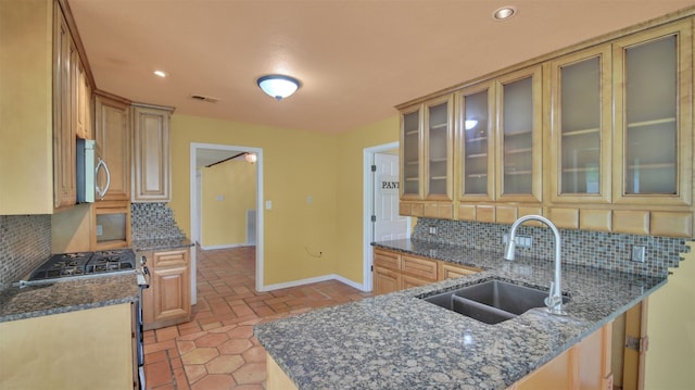 kitchen featuring a sink, stainless steel appliances, baseboards, backsplash, and recessed lighting