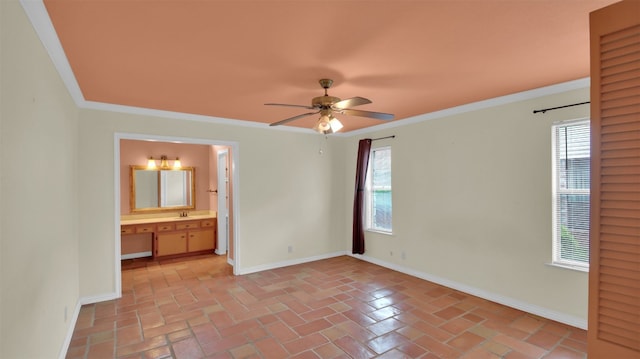 empty room with a ceiling fan, baseboards, and crown molding