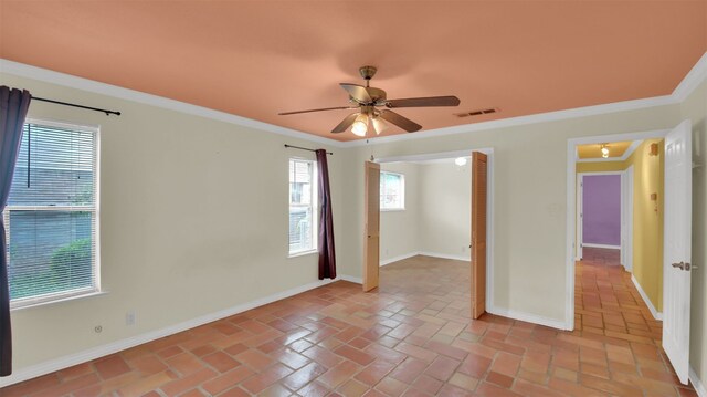 unfurnished room featuring a ceiling fan, baseboards, ornamental molding, and brick flooring