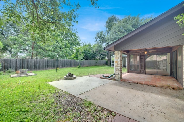 view of yard featuring an outdoor fire pit, a patio area, a ceiling fan, and view of wooded area
