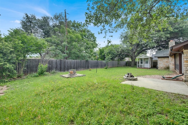 view of yard with a fire pit, a patio area, and an outdoor structure