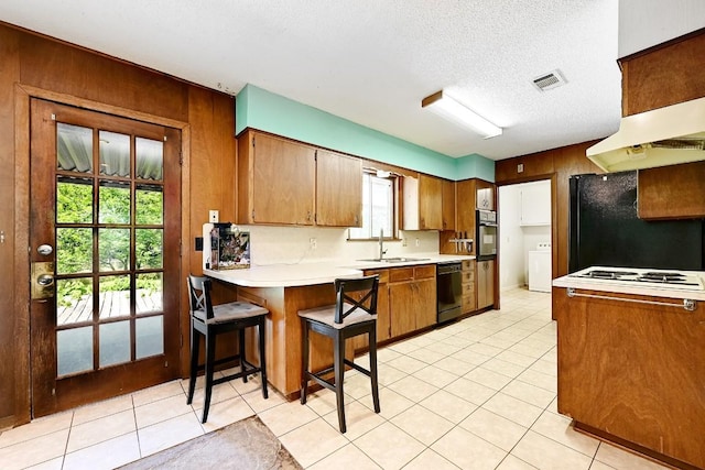3305 Carol Ann Dr, Austin, TX 78723 - kitchen featuring black appliances, a sink, light countertops, a peninsula, and a textured ceiling