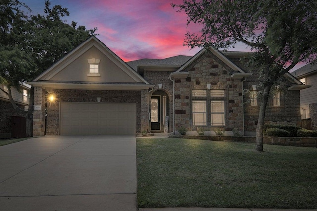 109 Lake Livingston Dr, Georgetown, TX 78628 - view of front of property featuring concrete driveway, a yard, stone siding, an attached garage, and stucco siding