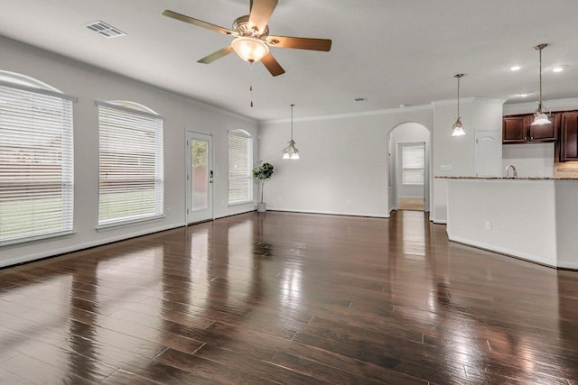 109 Lake Livingston Dr, Georgetown, TX 78628 - unfurnished living room featuring arched walkways, ceiling fan, ornamental molding, wood finished floors, and recessed lighting