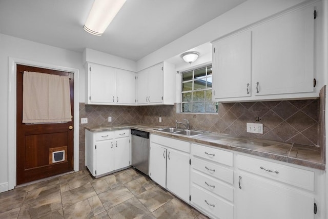 kitchen with dishwasher, a sink, white cabinets, and backsplash