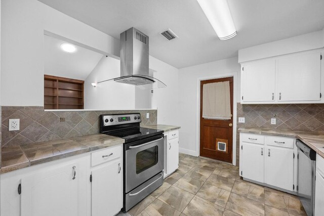 8006 Red Willow Dr, Austin, TX 78736 - kitchen featuring appliances with stainless steel finishes, island exhaust hood, white cabinets, and decorative backsplash