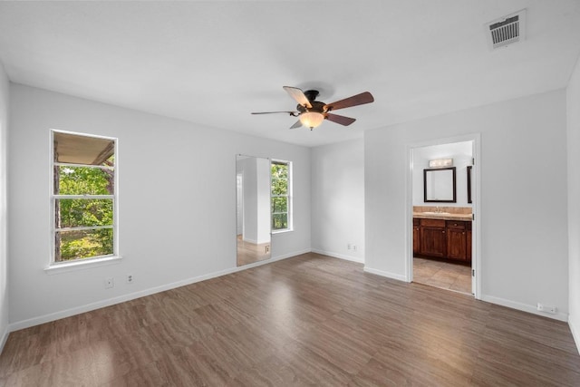 unfurnished room with light wood finished floors, a ceiling fan, and baseboards