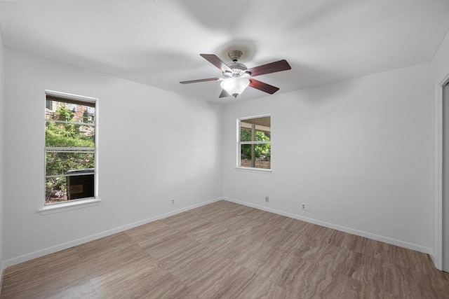 spare room featuring ceiling fan and baseboards