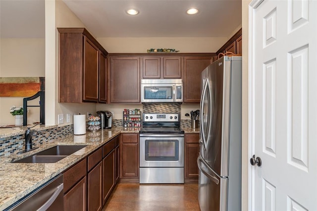 17219 Oak Cliff Cir, Dripping Springs, TX 78620 - kitchen featuring stainless steel appliances, a sink, light stone countertops, decorative backsplash, and recessed lighting