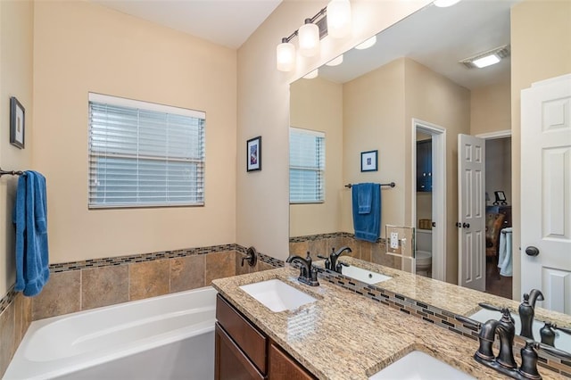 17219 Oak Cliff Cir, Dripping Springs, TX 78620 - bathroom featuring a garden tub, toilet, and double vanity
