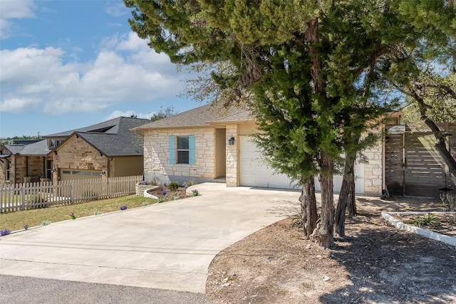 17219 Oak Cliff Cir, Dripping Springs, TX 78620 - view of front facade with stone siding, an attached garage, concrete driveway, and a shingled roof