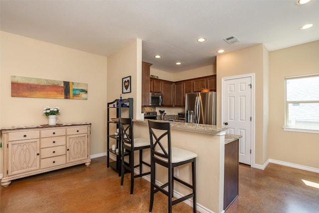 17219 Oak Cliff Cir, Dripping Springs, TX 78620 - kitchen featuring appliances with stainless steel finishes, baseboards, a breakfast bar, recessed lighting, and a peninsula