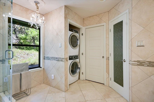 1004 Castle Ridge Rd, Austin, TX 78746 - washroom featuring stacked washer / drying machine, a chandelier, tile walls, and tile patterned floors