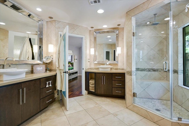 1004 Castle Ridge Rd, Austin, TX 78746 - bathroom with a shower stall, tile walls, two vanities, tile patterned flooring, and recessed lighting