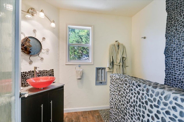 1004 Castle Ridge Rd, Austin, TX 78746 - bathroom with heating unit, wood finished floors, vanity, and baseboards