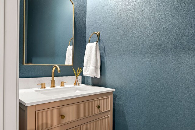 bathroom with vanity and a textured wall