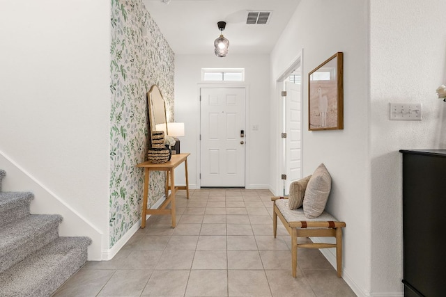 entryway featuring baseboards, light tile patterned floors, stairway, and wallpapered walls