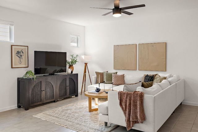 tiled living room with ceiling fan and baseboards