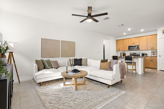 living room with light tile patterned flooring, a ceiling fan, recessed lighting, and baseboards