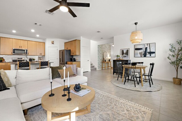 living room with stairs, ceiling fan, light tile patterned floors, recessed lighting, and baseboards