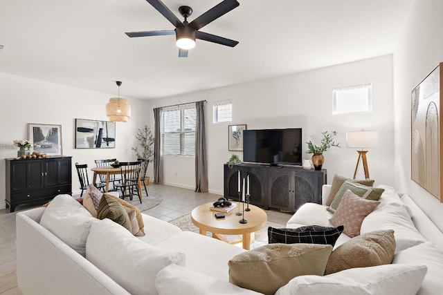 living area featuring a ceiling fan and baseboards