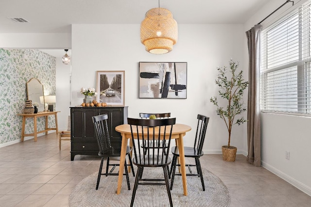 dining room featuring light tile patterned floors, baseboards, and wallpapered walls