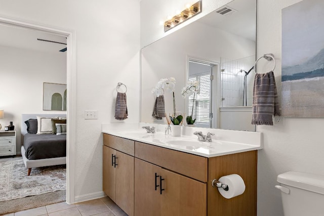 full bath with toilet, connected bathroom, double vanity, and tile patterned flooring