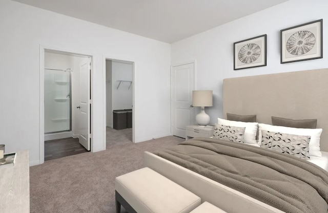 carpeted bedroom with a walk in closet, ensuite bath, and baseboards