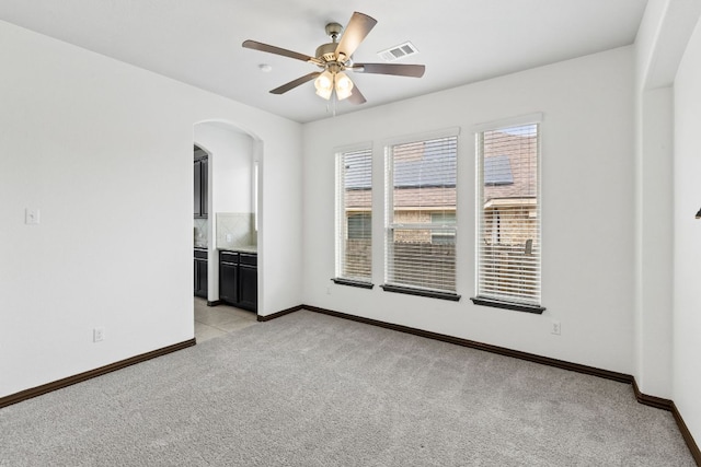 221 Mandana St, Leander, TX 78641 - spare room featuring light carpet, arched walkways, and a ceiling fan
