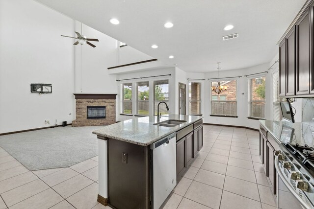 221 Mandana St, Leander, TX 78641 - kitchen featuring stainless steel appliances, light tile patterned flooring, a chandelier, a fireplace, and recessed lighting