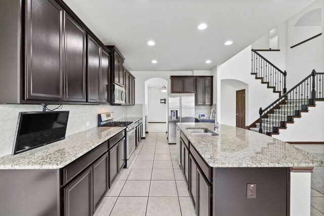 221 Mandana St, Leander, TX 78641 - kitchen featuring appliances with stainless steel finishes, arched walkways, decorative backsplash, and recessed lighting