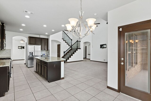 221 Mandana St, Leander, TX 78641 - kitchen with arched walkways, appliances with stainless steel finishes, backsplash, light tile patterned floors, and recessed lighting