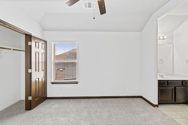 221 Mandana St, Leander, TX 78641 - unfurnished bedroom featuring lofted ceiling, light colored carpet, connected bathroom, and a ceiling fan