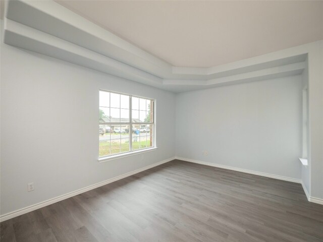 empty room with dark wood-type flooring and baseboards