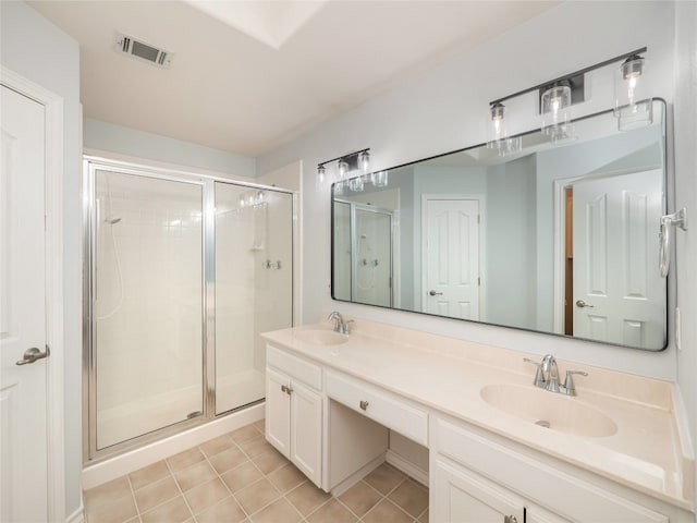 bathroom with a stall shower, double vanity, and tile patterned flooring