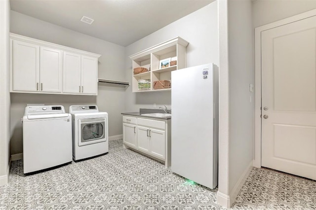 laundry area with separate washer and dryer, baseboards, and cabinet space