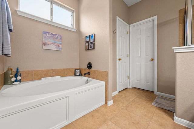 191 Fresno Spgs, Buda, TX 78610 - bathroom with a garden tub, baseboards, and tile patterned flooring