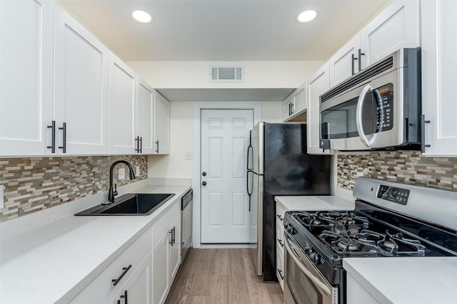 2105 Emerald Isle Dr, Leander, TX 78641 - kitchen featuring stainless steel appliances, a sink, white cabinets, light countertops, and recessed lighting