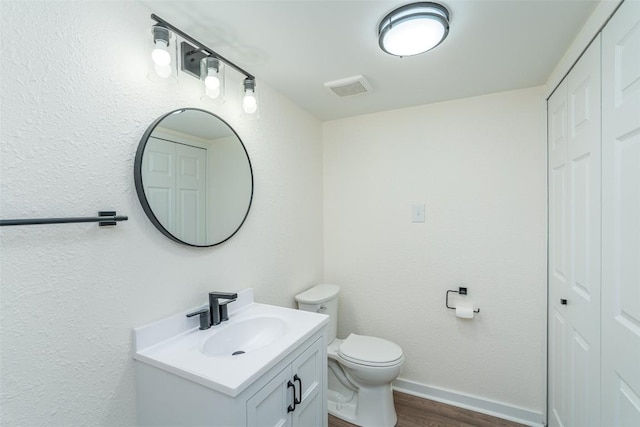 2105 Emerald Isle Dr, Leander, TX 78641 - bathroom featuring wood finished floors, vanity, toilet, baseboards, and a closet