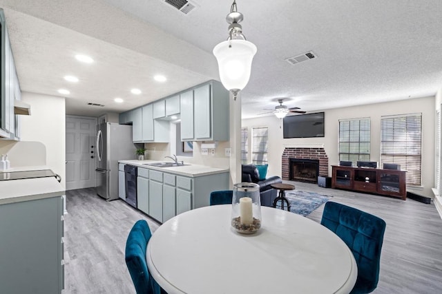 8805 Clearbrook Trl Unit A, Austin, TX 78729 - dining space featuring a ceiling fan, a textured ceiling, a fireplace, light wood finished floors, and recessed lighting