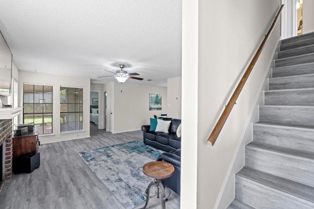 8805 Clearbrook Trl Unit A, Austin, TX 78729 - stairs featuring a fireplace, a ceiling fan, wood finished floors, and a textured ceiling
