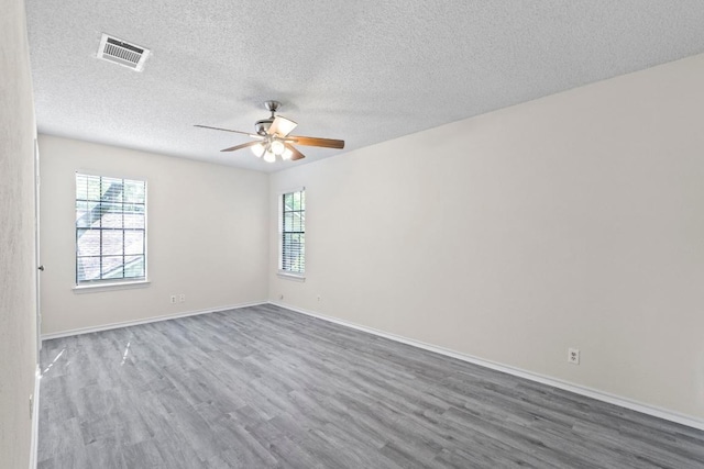 8805 Clearbrook Trl Unit A, Austin, TX 78729 - spare room with wood finished floors, a ceiling fan, healthy amount of natural light, and a textured ceiling