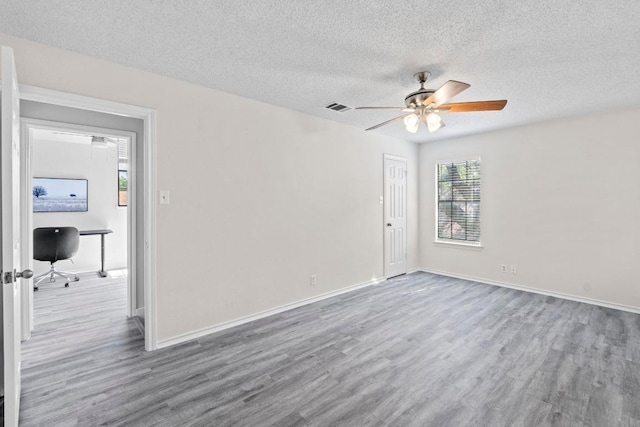 8805 Clearbrook Trl Unit A, Austin, TX 78729 - unfurnished room featuring wood finished floors, a desk, ceiling fan, and a textured ceiling