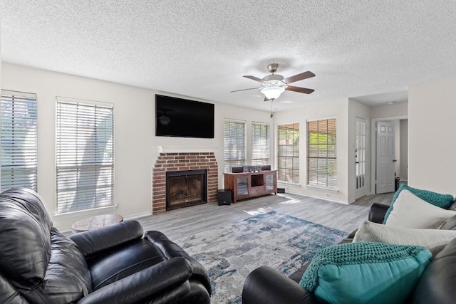 8805 Clearbrook Trl Unit A, Austin, TX 78729 - living area featuring a ceiling fan, wood finished floors, a textured ceiling, a brick fireplace, and baseboards